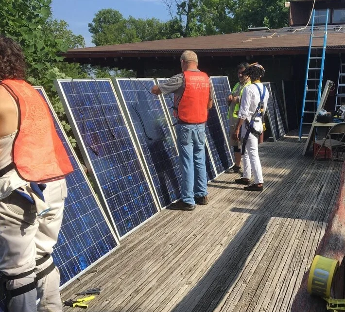 Solar installation crew preparing photovoltaic panels for a rooftop solar project